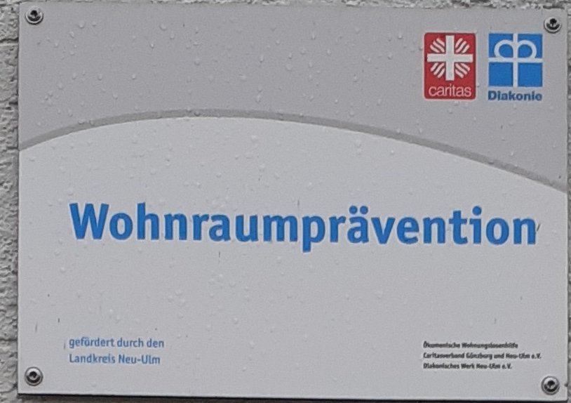 Schild am Eingang der Wohnungslosenhilfe