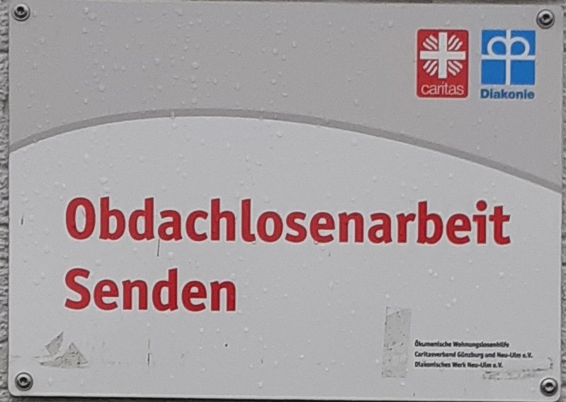 Schild am Eingang der Wohnungslosenhilfe